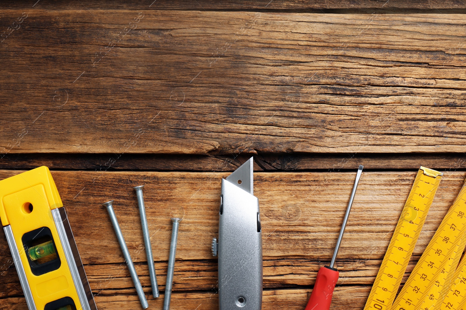 Photo of Flat lay composition with utility knife and different tools on wooden table. Space for text