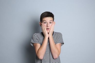 Photo of Portrait of surprised teenage boy on grey background