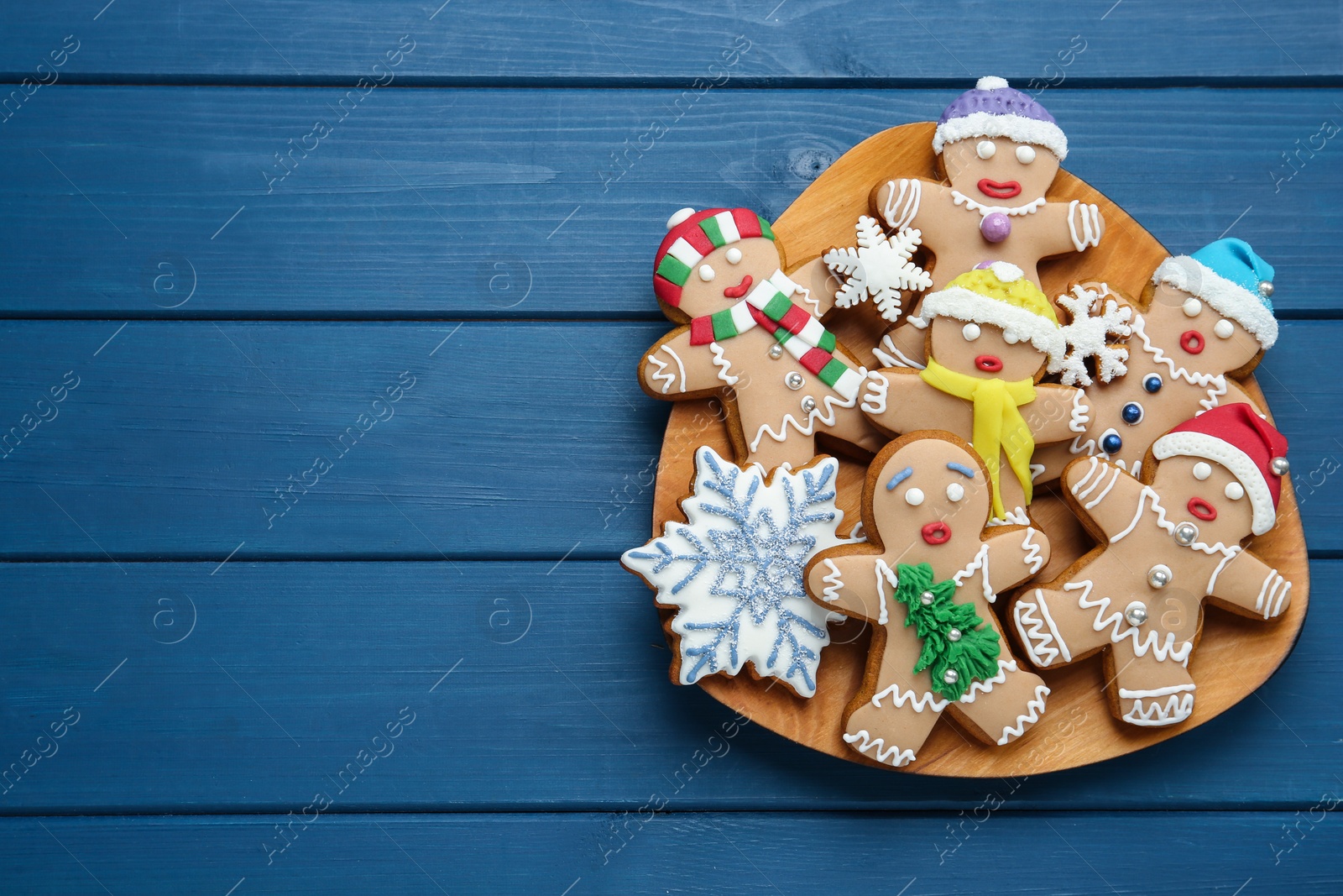 Photo of Delicious Christmas cookies on blue wooden table, top view. Space for text