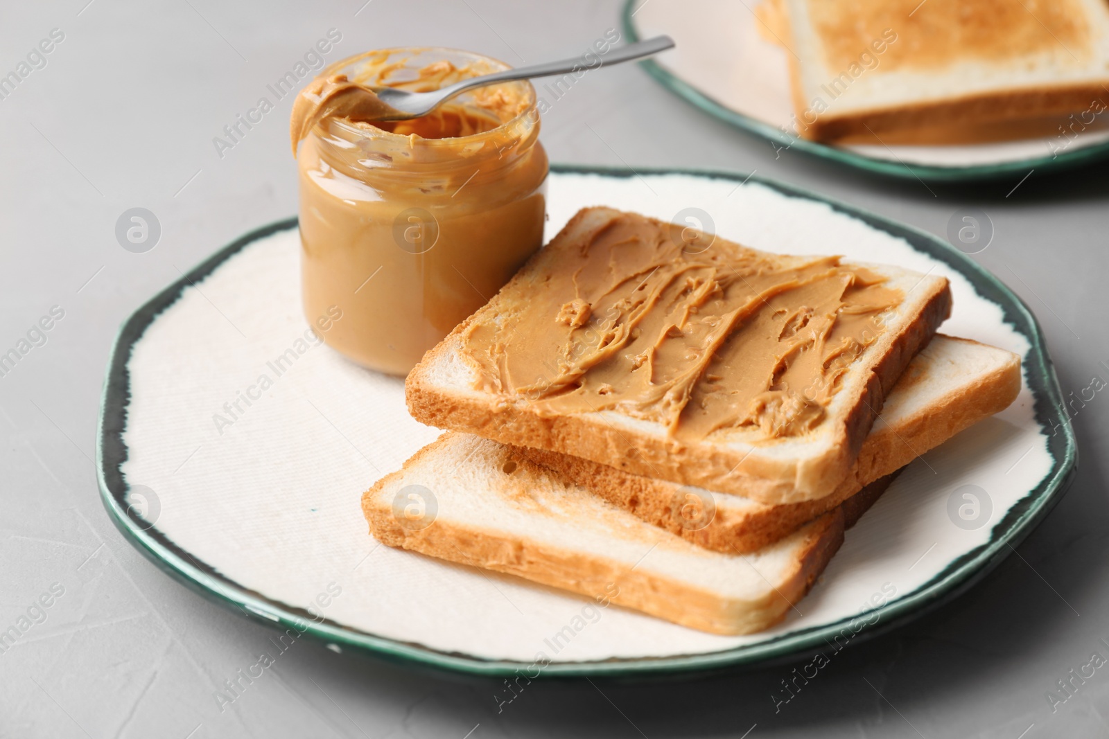 Photo of Plate with toasts and peanut butter on table