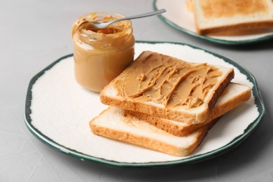 Plate with toasts and peanut butter on table