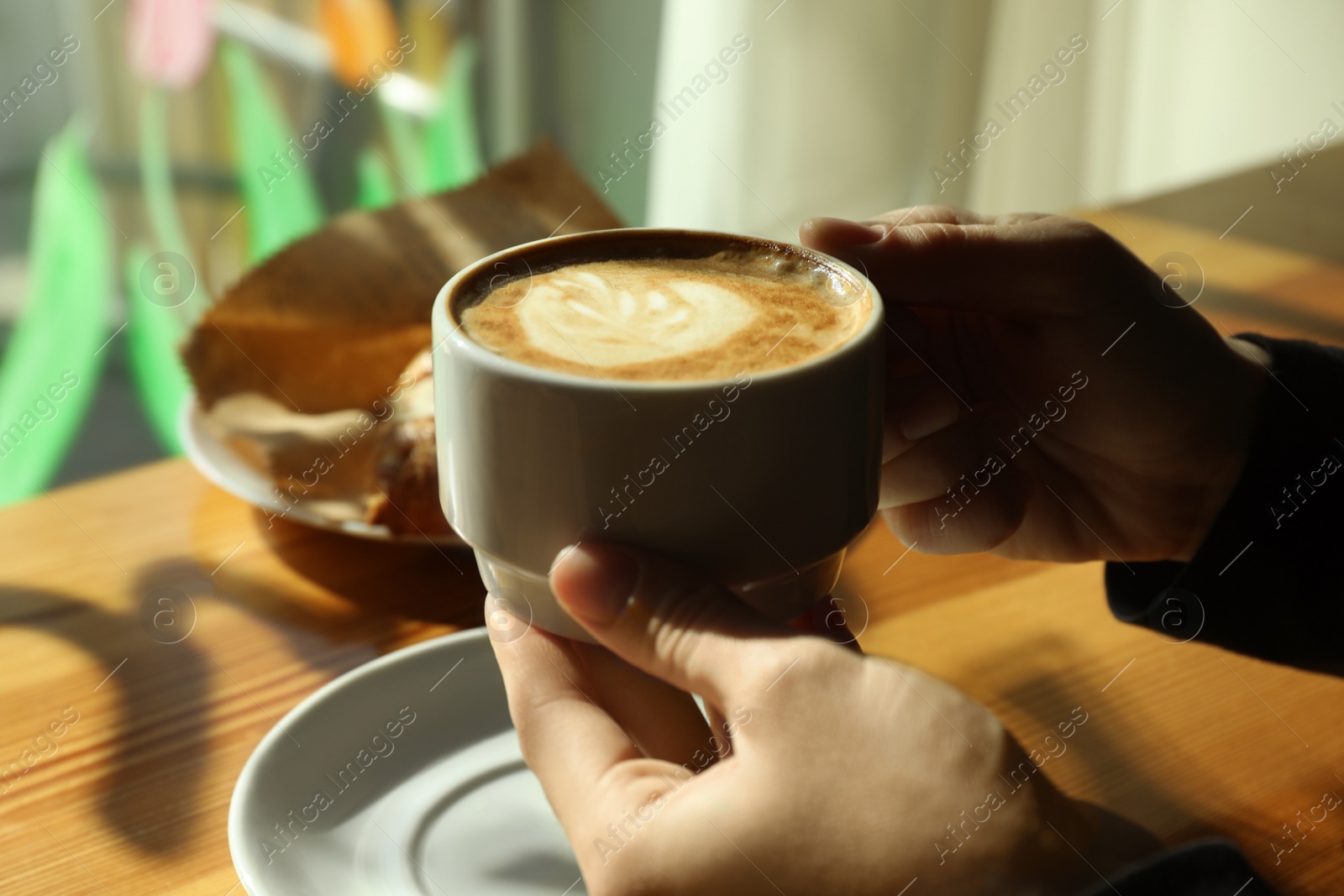 Photo of Woman with cup of fresh aromatic coffee at table in cafe