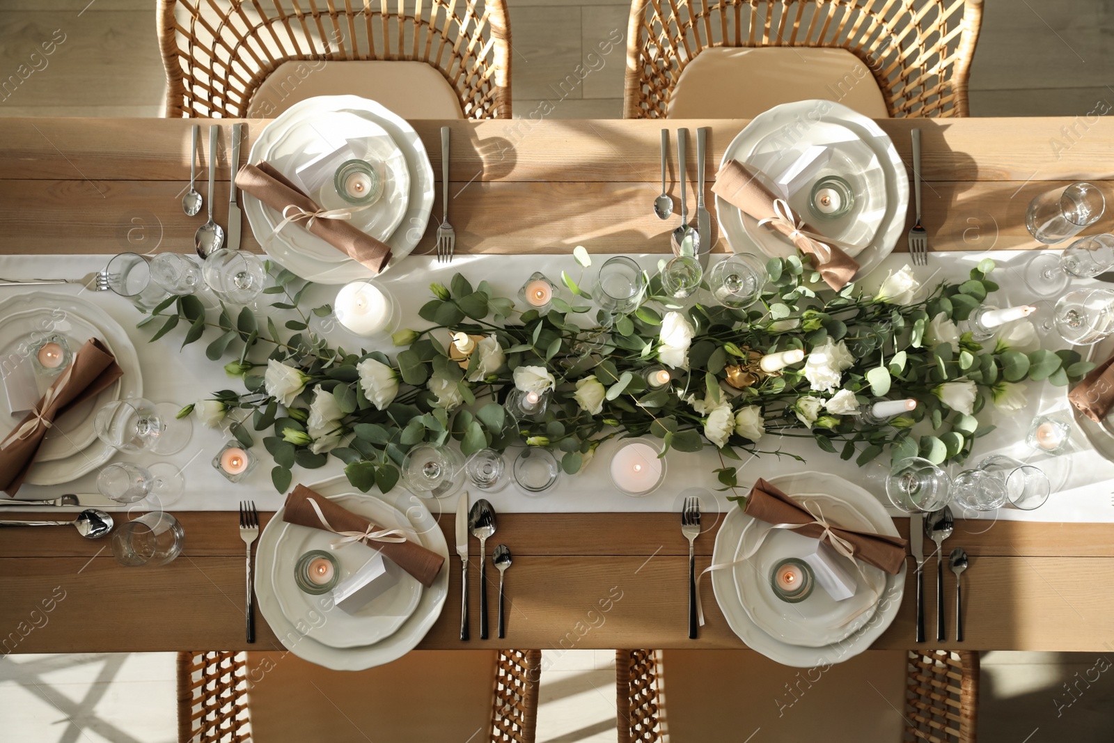 Photo of Elegant table setting with beautiful floral decor and burning candles, top view