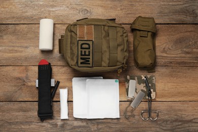 Photo of Flat lay composition with military first aid kit on wooden table