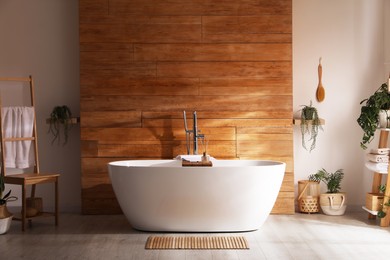 Photo of White tub and beautiful plants in bathroom, Interior design