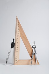 Photo of Triangle ruler and compasses on white background
