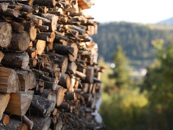 Pile of dry firewood outdoors, space for text