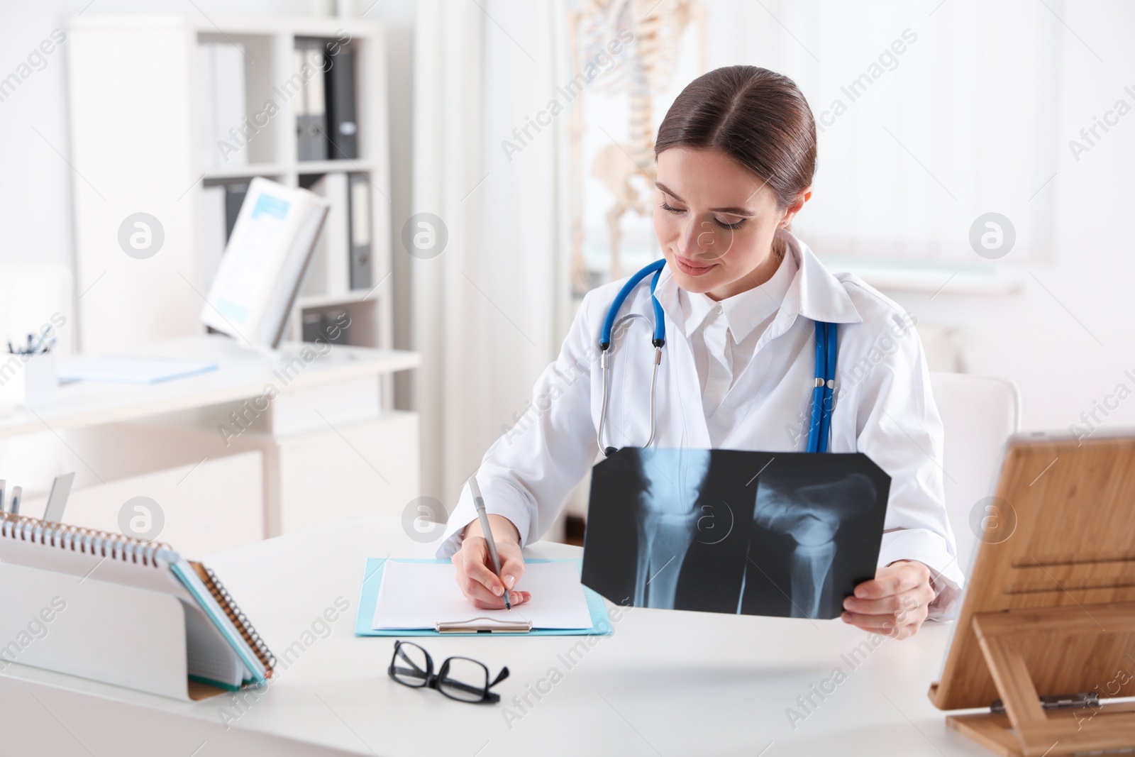 Photo of Orthopedist examining X-ray picture at desk in clinic