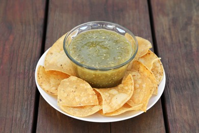 Photo of Tasty salsa sauce and tortilla chips on wooden table, closeup