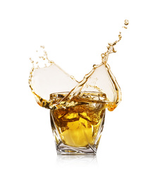 Whiskey splashing in glass on white background