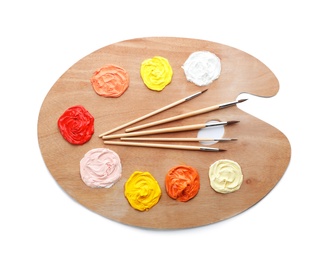 Photo of Palette with paints and brushes on white background, top view