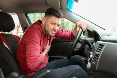 Photo of Mature man suffering from heart attack in car