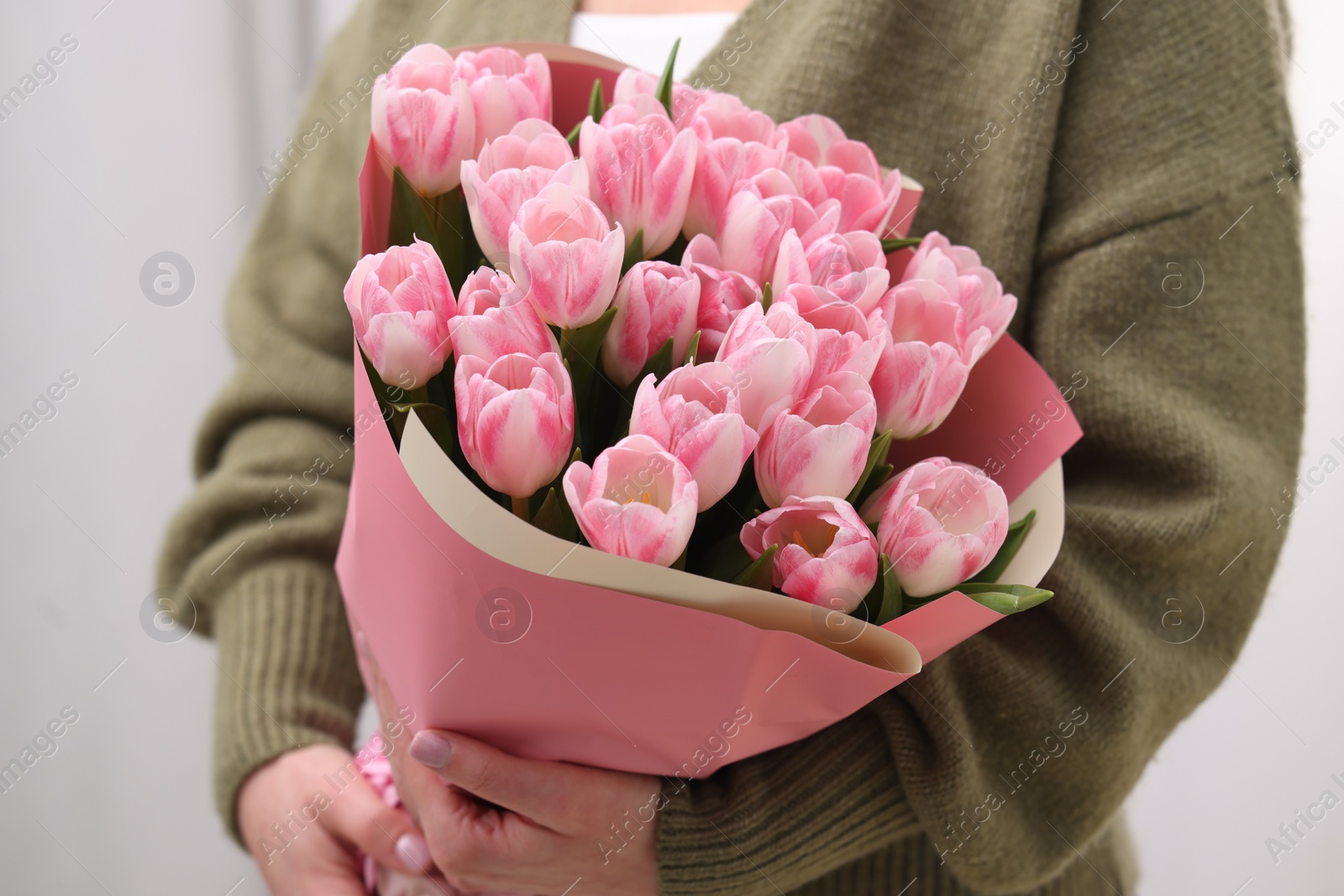 Photo of Woman with bouquet of beautiful fresh tulips on blurred background, closeup