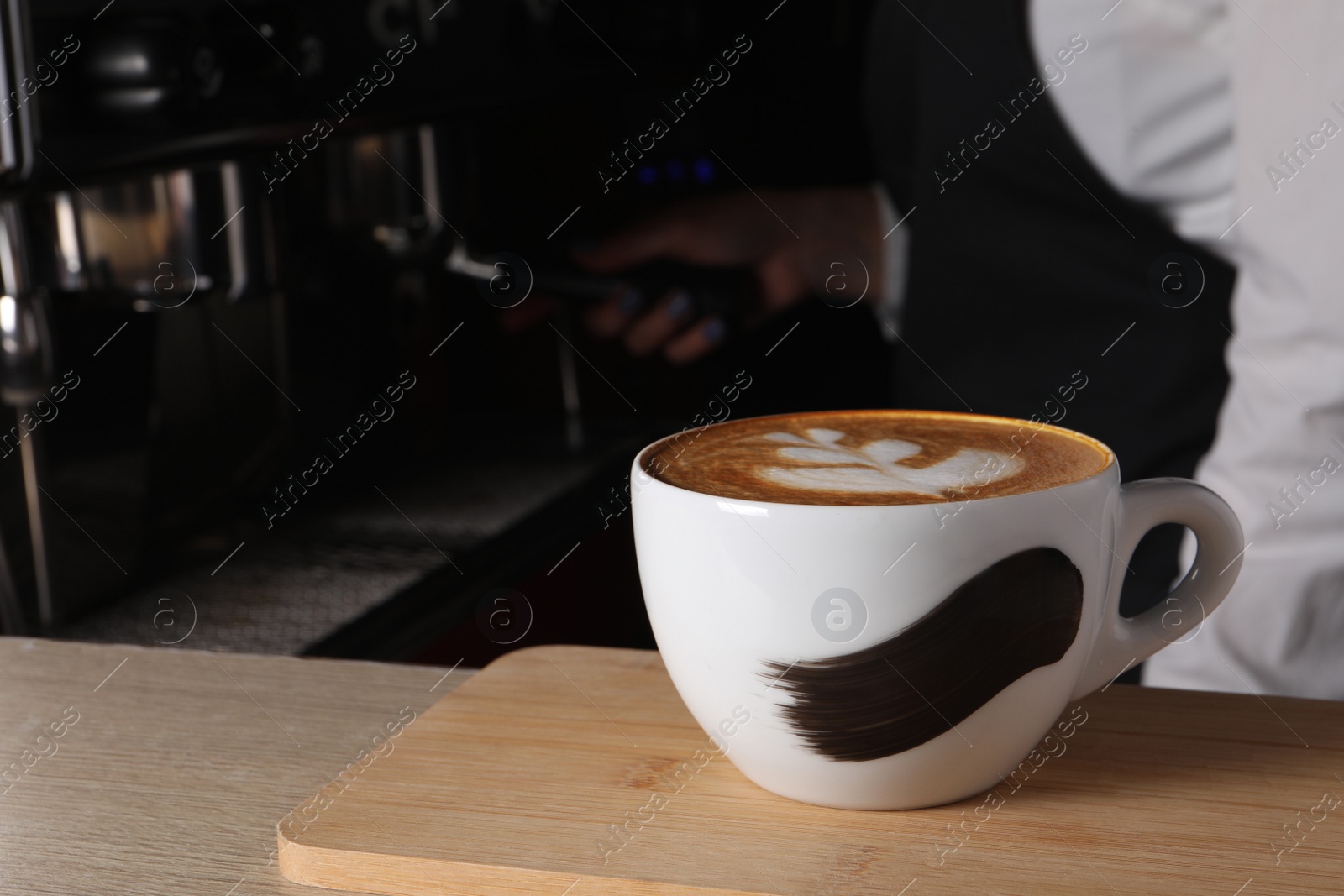 Photo of Barista working in cafe, focus on counter with cup of fresh aromatic coffee. Space for text