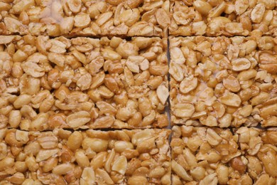 Photo of Delicious peanut bars (kozinaki) as background, top view