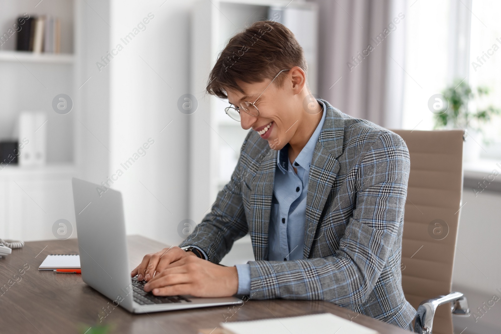 Photo of Man watching webinar at wooden table in office