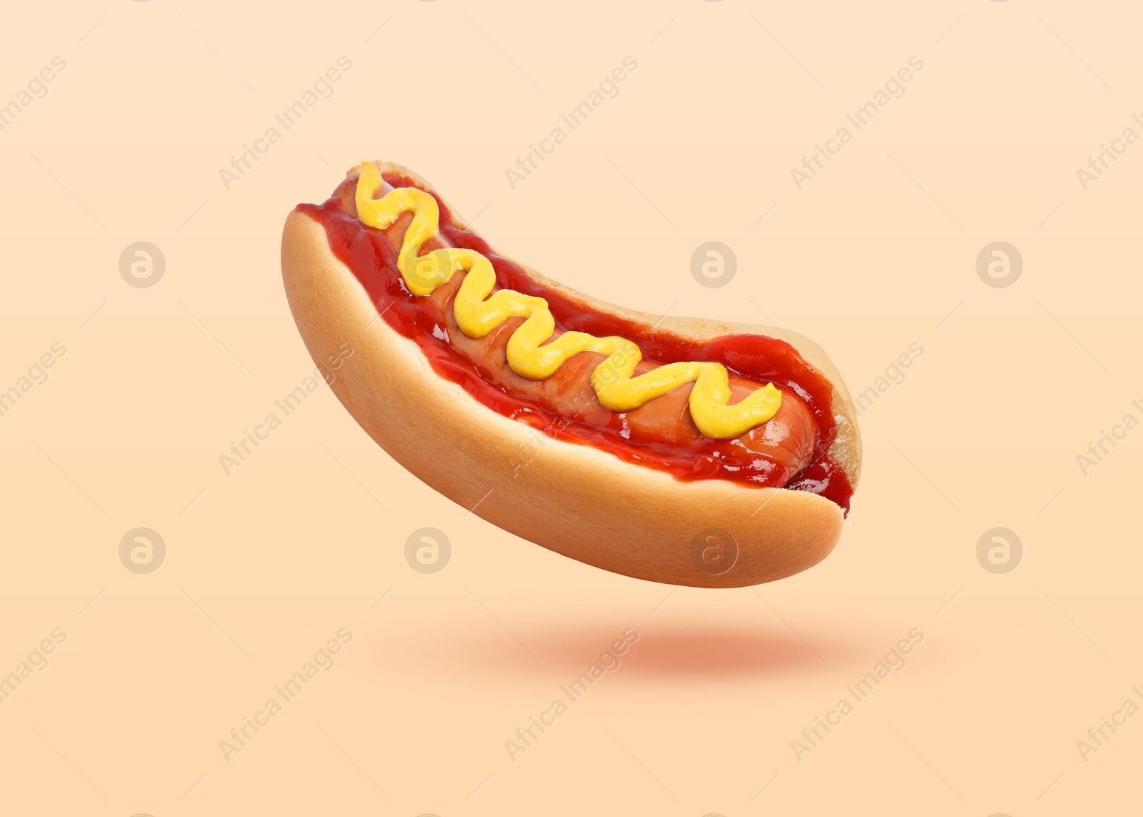 Image of Yummy hot dog with ketchup and mustard in air against beige background