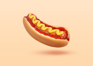 Yummy hot dog with ketchup and mustard in air against beige background