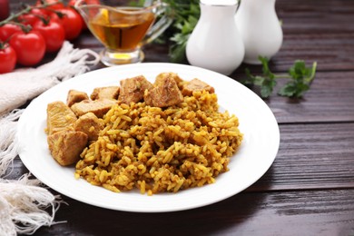 Photo of Delicious rice with chicken served on wooden table, closeup