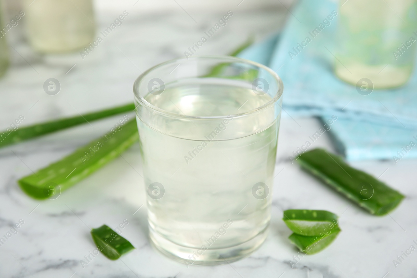 Photo of Fresh aloe drink in glass on white marble table, closeup