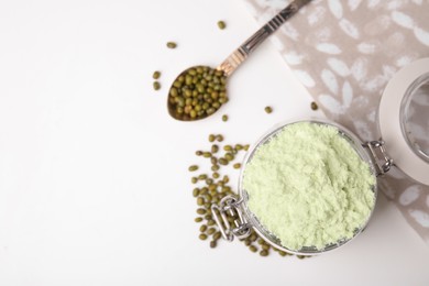 Photo of Glass jar with flour, spoon and mung beans on white table, flat lay. Space for text