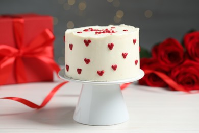 Photo of Bento cake, gift box and roses on white wooden table. St. Valentine's day surprise