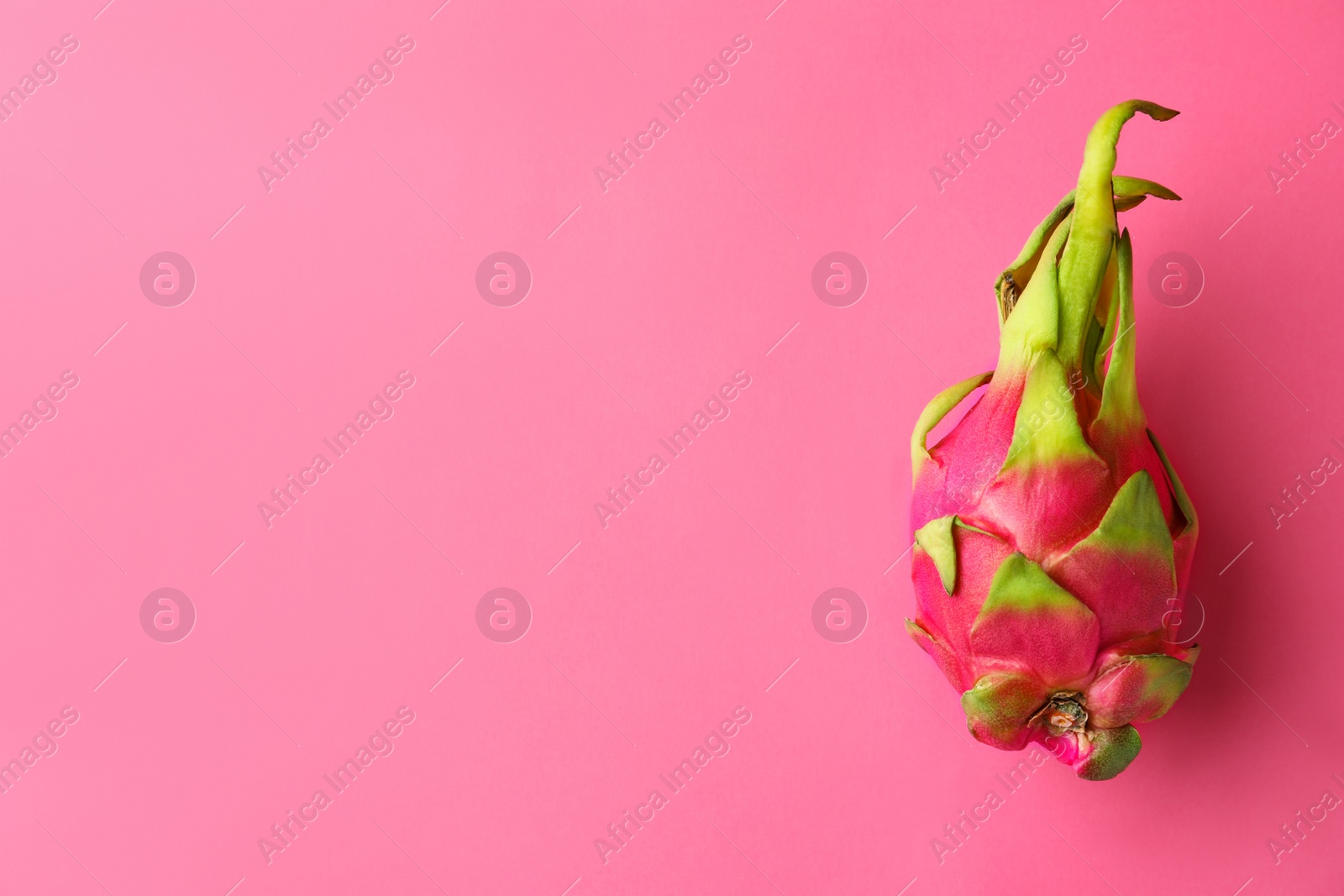 Photo of Delicious ripe dragon fruit (pitahaya) on pink background, top view. Space for text