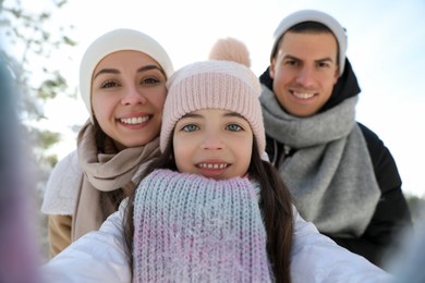 Happy family taking selfie outdoors on winter day. Christmas vacation