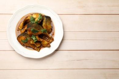 Photo of Tasty fish curry on white wooden table, top view. Space for text. Indian cuisine