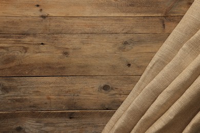 Burlap fabric on wooden table, top view. Space for text