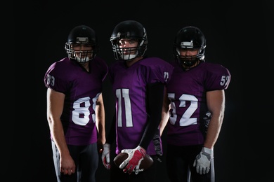 Photo of American football players in uniform on dark background