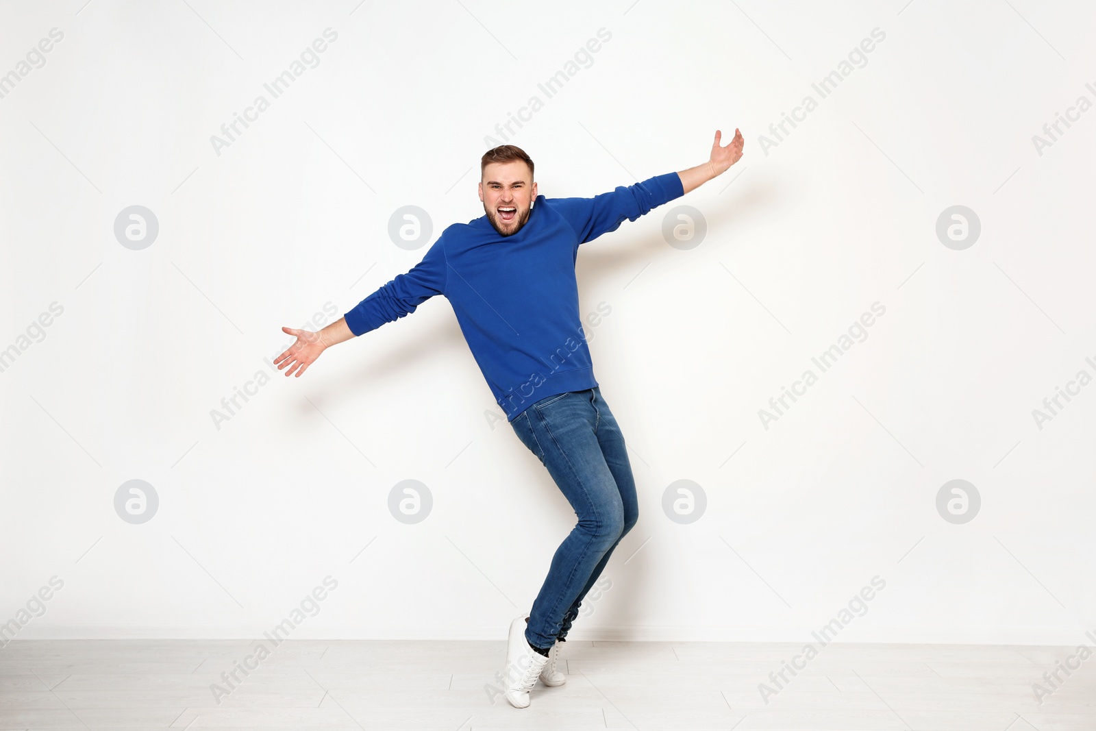 Photo of Full length portrait of emotional man against white wall