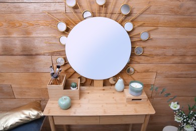 Photo of Dressing table with decor near wooden wall in room