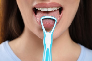 Woman brushing her tongue with cleaner, closeup