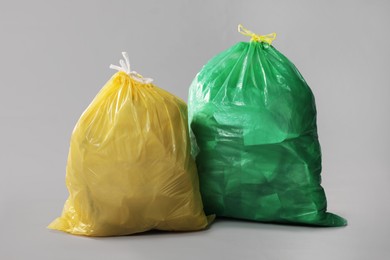 Photo of Trash bags full of garbage on grey background