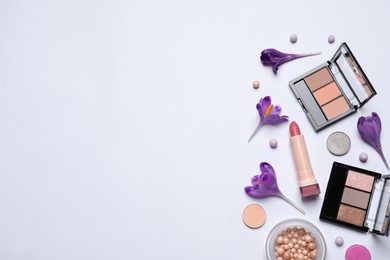Photo of Flat lay composition with different makeup products and beautiful flowers on white background. Space for text