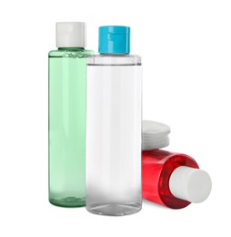 Bottles of micellar cleansing water and cotton pads on white background