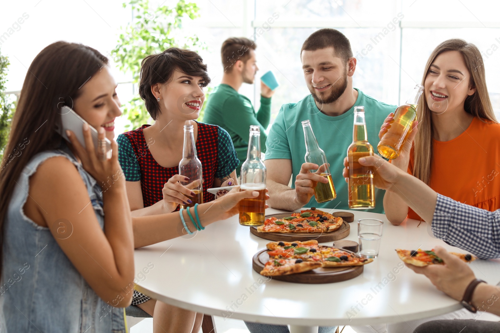 Photo of Young people having fun party with delicious pizza indoors