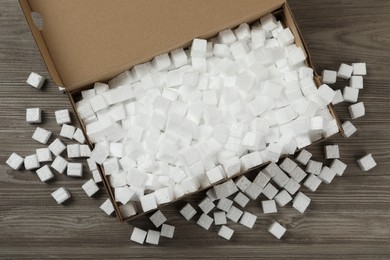 Photo of Cardboard box and styrofoam cubes on wooden floor, flat lay