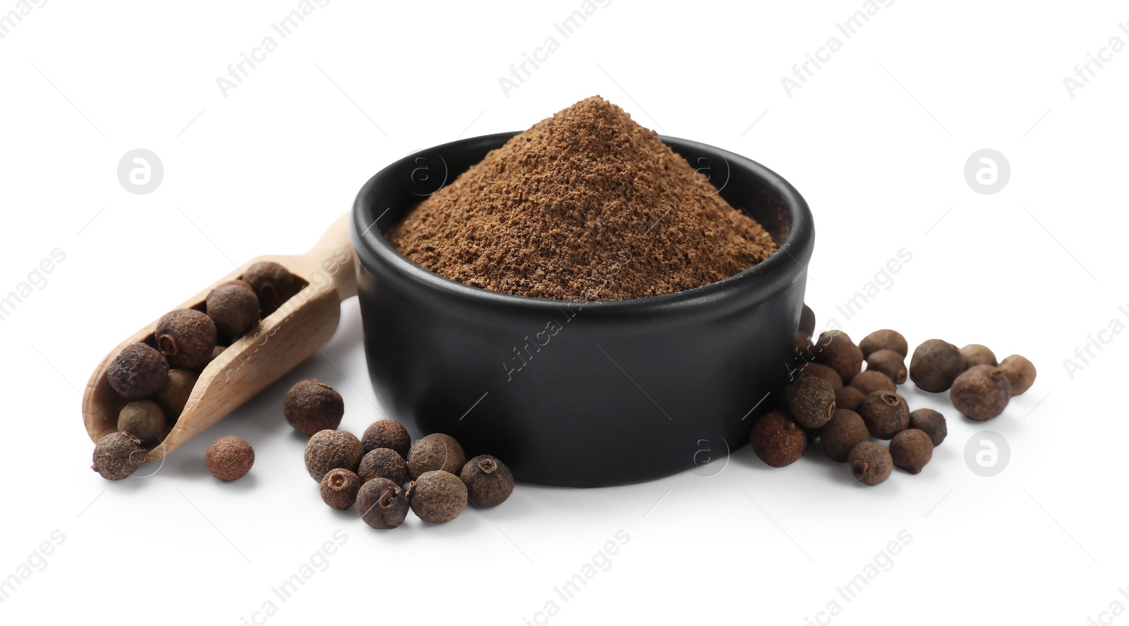 Photo of Ground allspice pepper in bowl, grains and scoop isolated on white