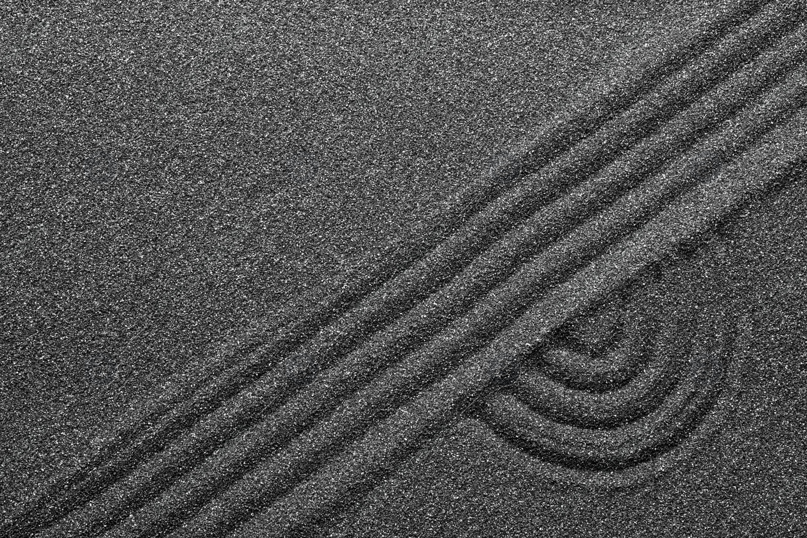 Photo of Pattern on decorative black sand, top view. Zen and harmony