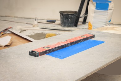 Photo of Red construction level on ceramic tile indoors