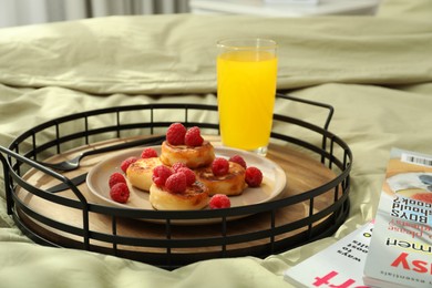 Tasty breakfast served in bedroom. Cottage cheese pancakes with fresh raspberries and juice on tray