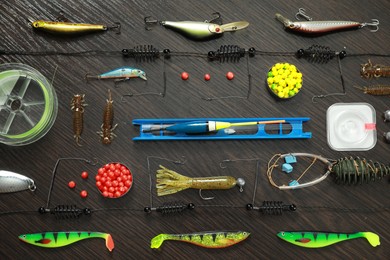 Photo of Fishing tackle on dark wooden background, flat lay