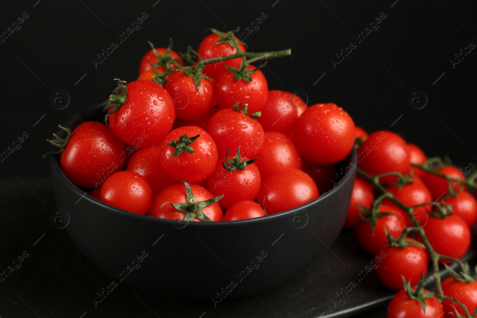 Photo of Fresh ripe cherry tomatoes with water drops on table, closeup