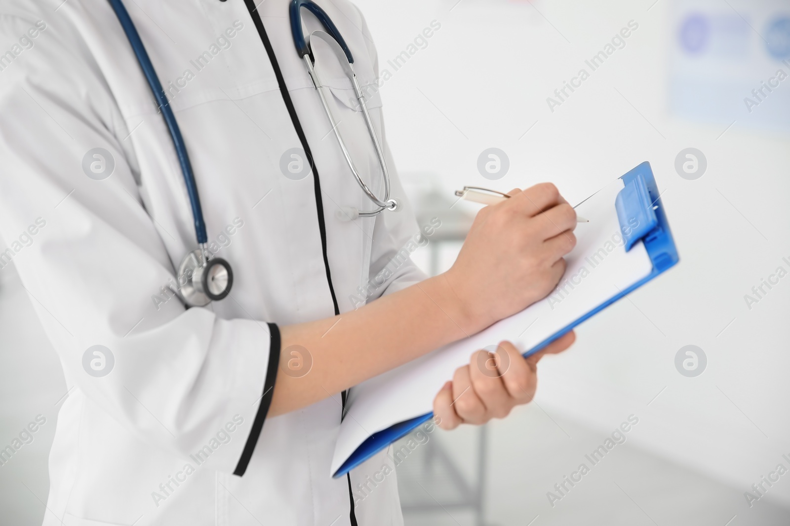 Photo of Young doctor with clipboard in hospital. Gynecology consultation