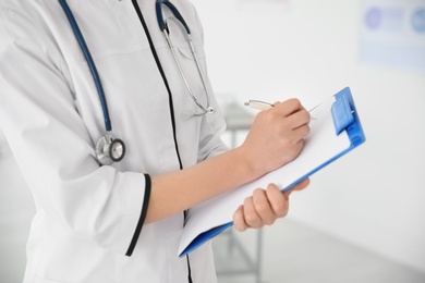 Photo of Young doctor with clipboard in hospital. Gynecology consultation