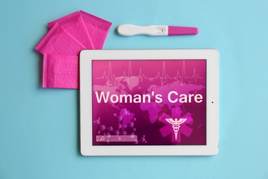 Photo of Flat lay composition with menstrual pads, tablet and pregnancy test on color background. Gynecological care