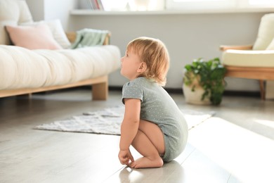 Photo of Cute baby learning to walk in living room