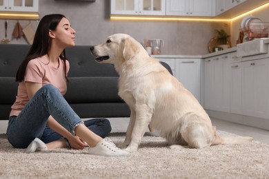 Photo of Happy woman with cute Labrador Retriever dog on floor at home. Adorable pet